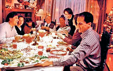 Family gathered at the dinner table enjoying Christmas dinner together.
