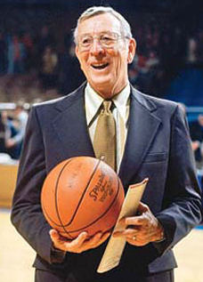 Coach John Wooden holding a basketball.