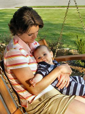 Mother and baby sitting in a porch swing.