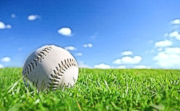 Baseball, green grass, blue sky, empty field.