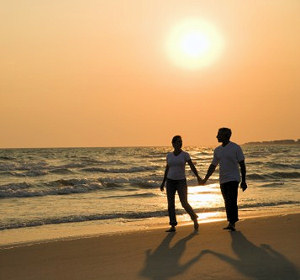 Husban and wife walking along the beach.