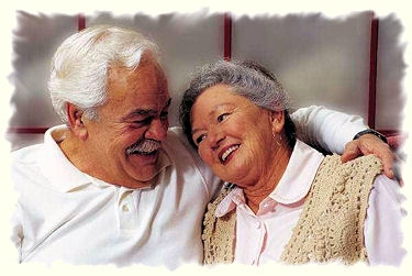 Elderly couple hug.