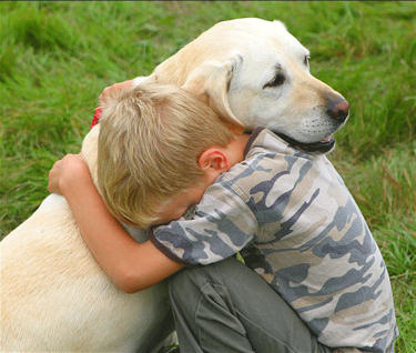 Boy hugging his loving dog.