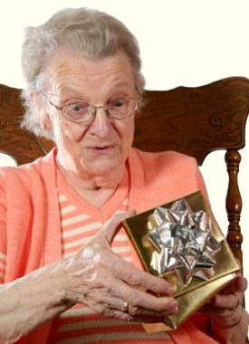 Smiling elderly lady in a rocking chair with a unexpected Christmas gift.