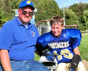 Proud father with his smiling football player son.