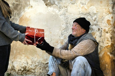 Unknown stranger gives a gift to a homeless man.