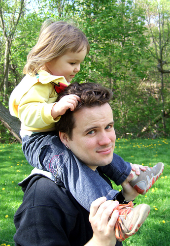 Little girl riding on daddy's shoulders.
