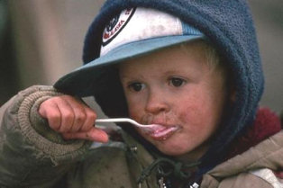 Hungry young boy eating.