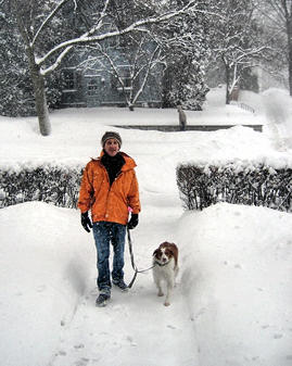 Man walking with his dog in the snow.