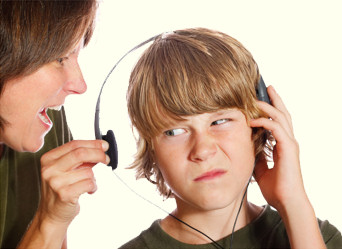 Picture of a mother pulling the headset off one ear of her son's head, so she could tell him about 'Life's Rules For Kids'.