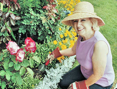 Older lady enjoying life and staying young at heart by gardening.