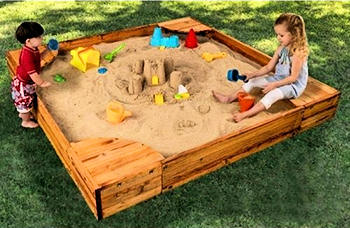 Boy and girl playing in a sandbox.