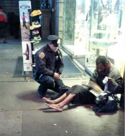 Policeman buying a pair of socks and boots, with his own money, for a homeless man without any socks or shoes.