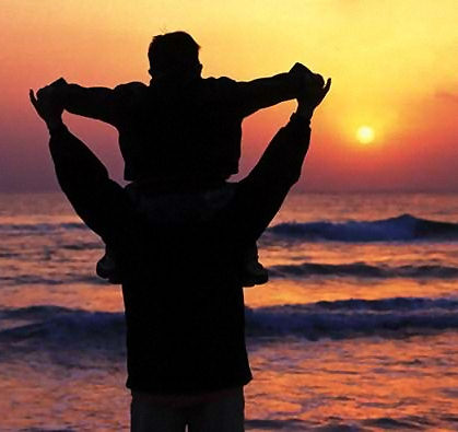 Father and son looking at a sunset.