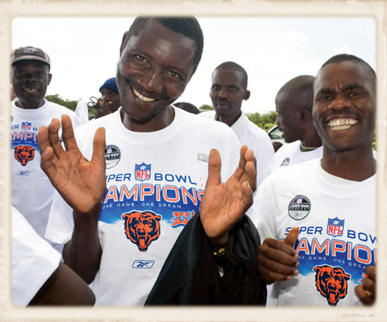 Smiling men in Africa wearing Super Bowl Tee Shirts.