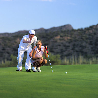 Old man and woman on a putting green.